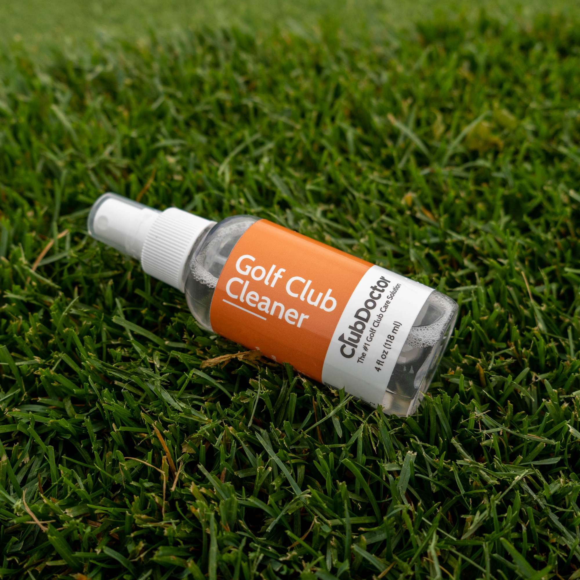 club doctor golf club cleaner bottle laying in the grass
